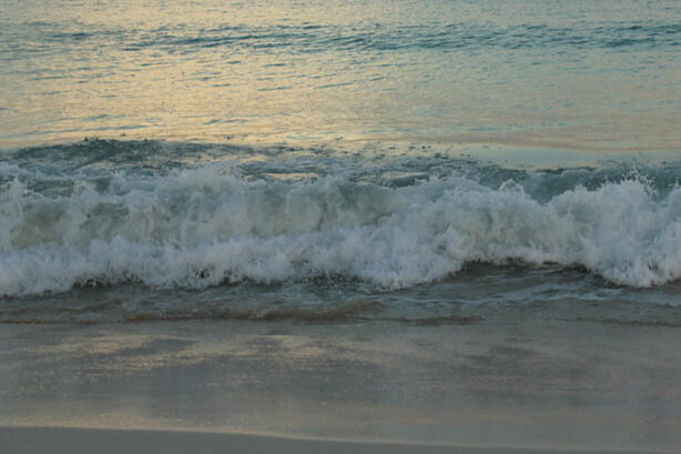 a beach with waves crashing on the sand